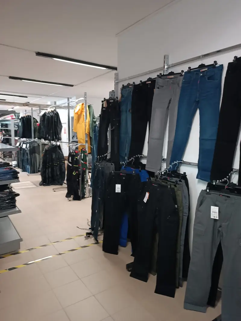 Pracovní kalhoty a džíny na stěně prodejny